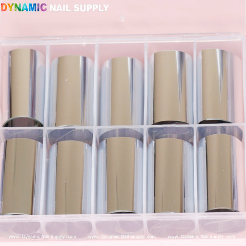 A pink plastic organizer from Dynamic Nail Supply contains eight rolls of shimmering plain silver style nail art foils. The foils are neatly arranged in two rows of four, with the brand name "DYNAMIC NAIL SUPPLY" prominently displayed at the top left corner in vibrant letters.