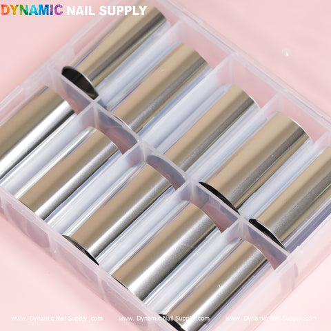 A transparent plastic organizer from Dynamic Nail Supply neatly stores rolled sheets of plain silver style metallic nail art foils. Branded with "Dynamic Nail Supply" in the top left corner, the box includes ten compartments for convenient access to each roll, ideal for adding a Silver Style flair against a soft pink backdrop.