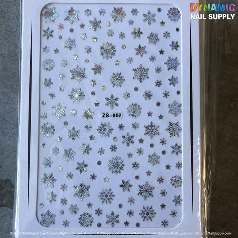 The Dynamic Nail Supply NAIL ART STICKERS - CHRISTMAS SNOW FLAKES NAILS STICKER (ZS-002) features a collection of holographic snowflake designs and small star stickers, all showcased on a white background. The code ZS002 is prominently displayed in the center.