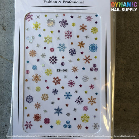 A sheet of nail art stickers from Dynamic Nail Supply, titled "NAIL ART STICKERS - CHRISTMAS SNOW FLAKES NAILS STICKER - ZS-003," features vibrant Christmas snowflakes and colorful flowers. The product, identified by ZS-003, is attractively displayed on a gray background.