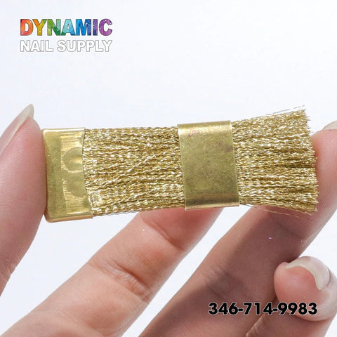 A close-up shows a hand holding the QH0600 Copper Wire Brush from Dynamic Nail Supply, featuring metal bristles and a rectangular gold base—perfect for cleaning nail drill bits. The white background accentuates the vibrant "DYNAMIC NAIL SUPPLY" text above. The phone number 346-714-9983 is displayed at the bottom right.