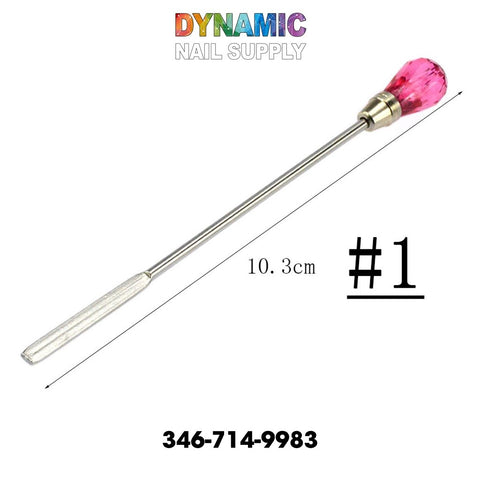 Introducing the QH3200 Nail Art Stirring Rod from Dynamic Nail Supply — a stainless steel spatula with a textured handle and a red, gem-like tip, perfect for manicures. Measuring 10.3 cm and marked as #1, this tool is ideal for all your nail art needs. The name "Dynamic Nail Supply" gleams in colorful letters on top, with their contact number, 346-714-9983, placed at the bottom for your convenience.