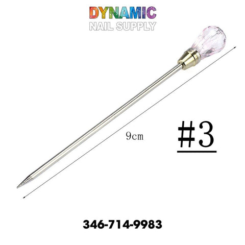 Image of the QH3200 Nail Art Stirring Rod Tools, featuring a stainless steel cuticle pusher with a pink gem-like handle, perfect for manicure enthusiasts. It is labeled as #3 and measures 9 cm. The vibrant "Dynamic Nail Supply" logo graces the top, while 346-714-9983 is displayed at the bottom, making it ideal for intricate nail art designs.