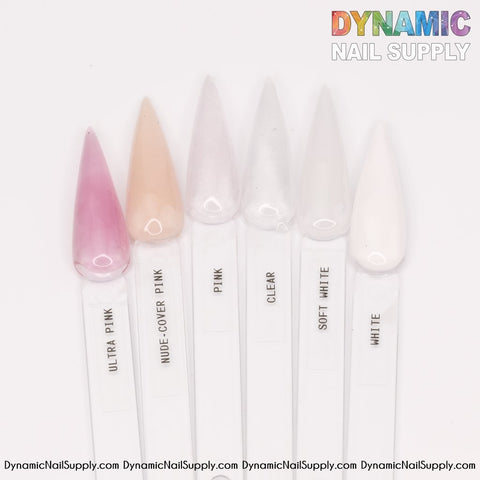 A set of six stiletto nail swatches highlights the excellence of Dynamic Nail Supply's acrylic powder, including shades like Ultra Pink, Nude Cover Pink, Pink, Clear, Soft White, and White for durable nails. The brand's logo is displayed in the top right corner with the website URL listed at the bottom.