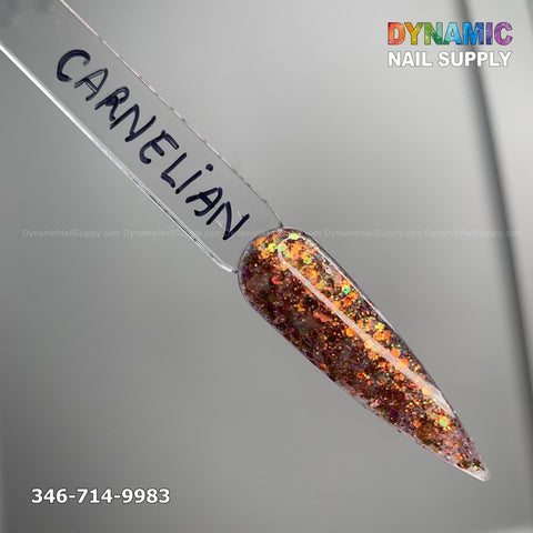 A sample of Carnelian #330 from Dynamic Nail Supply is displayed on a clear tip, featuring a glittery blend of orange, gold, and iridescent sparkles for achieving long-lasting nails. The Dynamic Nail Supply logo appears above in multicolored text, with the phone number 346-714-9983 located in the lower-left corner.