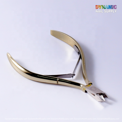The D501 Professional Stainless Steel Cuticle Nipper from Dynamic Nail Supply, essential for manicure tasks, showcases sharp, angled blades and a smooth spring mechanism. It is displayed lying open on a plain white background. The ergonomic handles are gently curved for added comfort, with Dynamic Nail Supply printed in colorful letters at the top right corner.