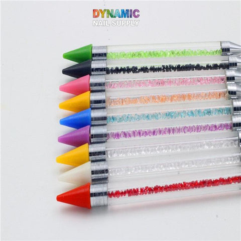 Experience the versatile Dual-head Rhinestone Picker Pen from Dynamic Nail Supply, a set of nine nail art tools with dual ends. Each pen features a solid-colored tip and a transparent body filled with matching decorative beads. Perfect for intricate nail designs, this set includes vibrant colors such as green, black, blue, yellow, pink, purple, white, orange, and red.