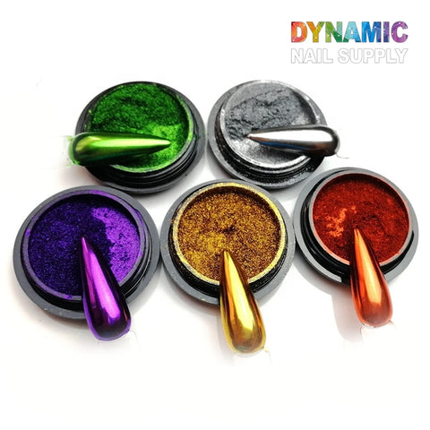 Five containers of Chrome Effect Nails: Metallic Chrome Pigment for Nail Design are displayed in a semicircle. These striking metallic shades of green, silver, purple, gold, and copper each include a nail tip to exhibit their reflective finish. The text "Dynamic Nail Supply" is artistically displayed in colorful letters at the top right corner, making it ideal for your next nail art creation.