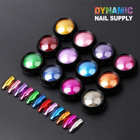 Introducing the Chrome Effect Nails collection by Dynamic Nail Supply: a set of 12 small round containers filled with metallic chrome pigments in assorted colors like gold, red, pink, green, purple, blue, orange, and silver. This set includes matching nail samples for creating dazzling nail art designs. The image backdrop is black and features the Dynamic Nail Supply branding.