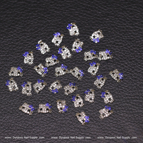 30 pcs Royal Blue Metal Hello Kitty Design Nail Charms on textured black leather with website text at the bottom.