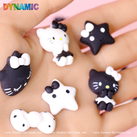 A hand holds 10 pcs Cute Hello Kitty Cat Cartoon Design Nail Charms on a soft pink background.