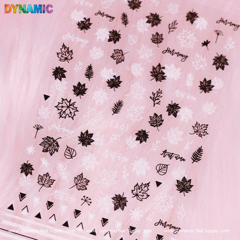 A sheet adorned with nail art stickers showcasing black and white fall leaves, triangles, and handwritten words like Autumn and Harmony is set against a subtle pink gradient background. It is labeled as F 661, with the branding of Dynamic Nail Supply displayed at the bottom edge.