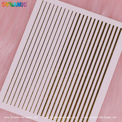 A sheet of thin, metallic gold nail art striping tape is laid out on a soft pink background, showcasing an abstract pattern with a parallel line design. The text "Dynamic" appears at the top left corner, while "Dynamic Nail Supply" is elegantly printed along the bottom edge of the sheet.