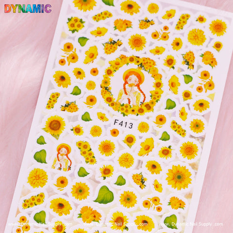 The nail art sticker sheet, named "Sunflowers (F413)" from Dynamic Nail Supply, features charming sunflowers with a smiley face in the center, surrounded by additional sunflowers. These designs are beautifully set against a light pink background, with the product code F413 discreetly incorporated.