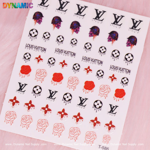 The Luxury Halloween Sticker (T-586) by Dynamic Nail Supply features a variety of designs, including the famous Louis Vuitton logo, red roses, and skulls with pink outlines for a spooky Halloween feel. Black LV motifs are prominently displayed against a soft pink background, with Dynamic Nail Supply branding on both ends.