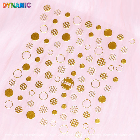 The Polka Dot, Circle Abstract Sticker (DP3215) from Dynamic Nail Supply showcases gold nail art stickers with circle abstract designs in varying diameters, set against a pink background. The stickers feature both solid circles and polka dot patterns. The DYNAMIC logo is prominently displayed in colorful letters at the top left corner, while a discreet website link is placed along the bottom edge.