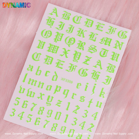 A vibrant sheet of neon green Roman letter and number stickers, featuring both uppercase and lowercase letters as well as numbers 0-9, is set against a pink furry background. The code XF3359 is prominently displayed at the bottom center, while the Dynamic Nail Supply branding is stylishly repeated along the bottom edge.
