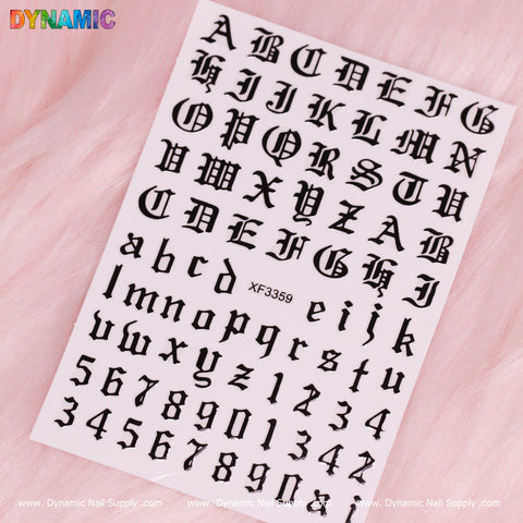 A set of Gothic-style Roman letter stickers, including both uppercase and lowercase alphabets, as well as number stickers from 0-9, displayed on a pink fuzzy background. The brand "Dynamic Nail Supply" is labeled in black at the bottom along with the product code XF3359.
