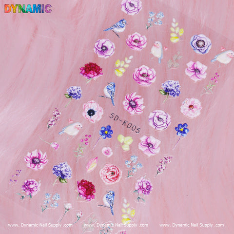 The Spring Floral Sticker (5D-K005) from Dynamic Nail Supply features vibrant designs on a pink background, including purple roses, pink peonies, bluebirds, and butterflies. With the DYNAMIC logo in the top left corner, it adds a touch of nature's beauty to your nails.