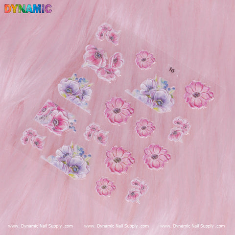 A sheet of Flower Sticker (16) by Dynamic Nail Supply featuring a collection of pink floral nail art stickers with designs of blossoms and buds on a clear background. The setting includes a soft pink fur texture, with "DYNAMIC" highlighted in colorful letters at the top left, and "Dynamic Nail Supply" repeated along the bottom.