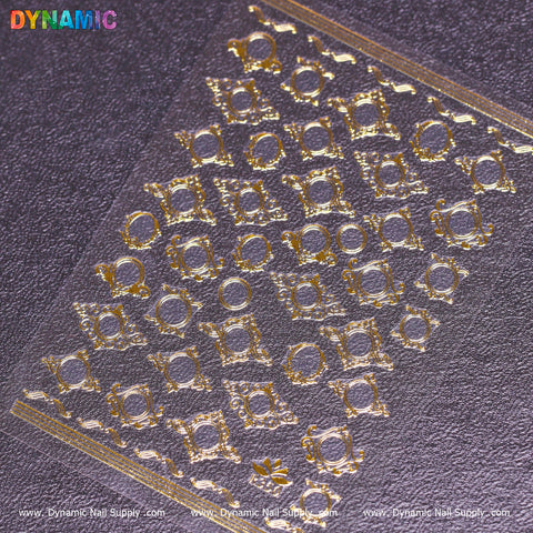 A Mirror Style Sticker (R350) sheet featuring intricate gold nail art designs, including geometric patterns and round details, is displayed on a textured purple surface. The image showcases the Dynamic Nail Supply logo in colorful text at the top left and includes the R350 website information at the bottom.