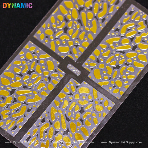 A close-up shows the gold nail sticker stencil from Dynamic Nail Supply's Animal Pattern Nail Sticker (SP219) collection. It features abstract, irregular shapes reminiscent of animal patterns, divided into sections by narrow borders. The brand name "Dynamic Nail Supply" appears in colorful letters in the top left corner against a dark background for contrast.