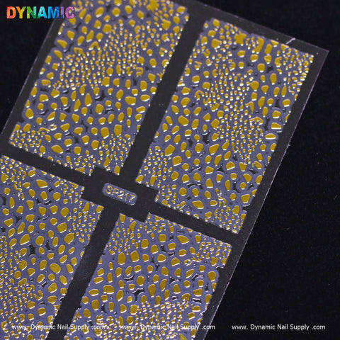 Close-up of the Dynamic Nail Supply Animal Pattern Nail Sticker (SP217) on a black background, highlighting abstract yellow and silver dotted patterns. The sheet is divided into rectangular sections, with vibrant dots forming a textured, playful design perfect for decorative nail application.