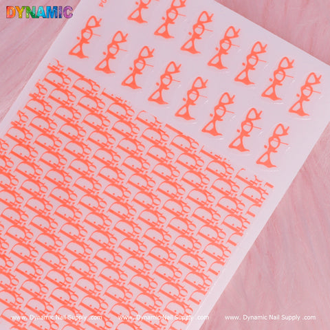 A sheet of neon red luxury water decals, showcasing elegant bow designs, is tastefully organized in rows against a soft pastel background. The word "Dynamic" is prominently displayed at the top in colorful letters, with the website www.DynamicNailSupply.com printed at the bottom for more trendy nail accessories.