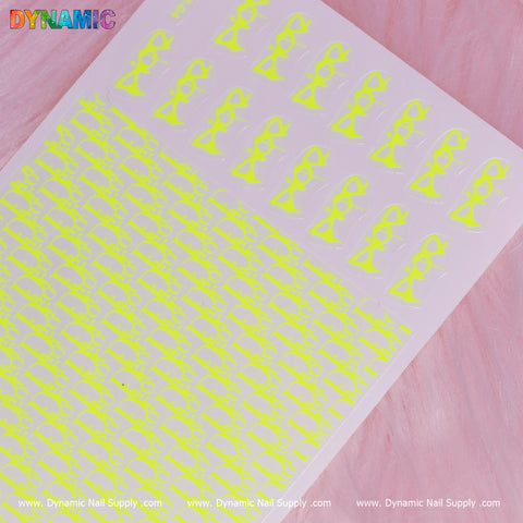 A sheet of neon yellow Luxury Water Decal (Lime) nail art stickers, embellished with playful pairs of sunglasses, is set against a pink textured background. The top corner prominently features the word "DYNAMIC" in colorful letters, enhancing the appeal with its luxurious lime hue. Explore www.DynamicNailSupply.com for more vibrant designs from Dynamic Nail Supply.