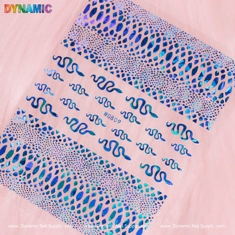 The Snake Skin Nail Water Decal (WG809) from Dynamic Nail Supply features wavy, abstract patterns and dotted lines in blue holographic designs. The soft pink background accentuates the text "DYNAMIC" and "Dynamic Nail Supply," with the notable code WG809 prominently displayed among these intriguing patterns.