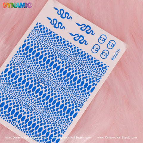 A detailed view of a nail art sticker sheet set against a pink fur background showcases intricate neon blue snake skin patterns and small, stylized blue snake designs in the top right. The Dynamic Nail Supply brand is prominently displayed in colorful letters on the top left corner, while website URLs are printed along the bottom edge.