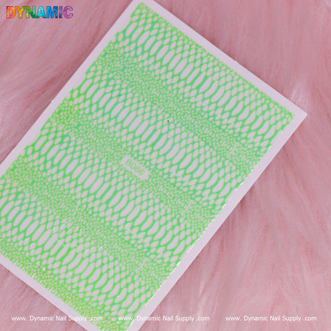 A rectangular sheet of the Snake Skin Nail Water Decal - Green (B066) is placed on a soft, pink, fur-like surface. The Dynamic Nail Supply logo is prominently displayed at the top in colorful lettering, complementing the green, lace-like patterns.