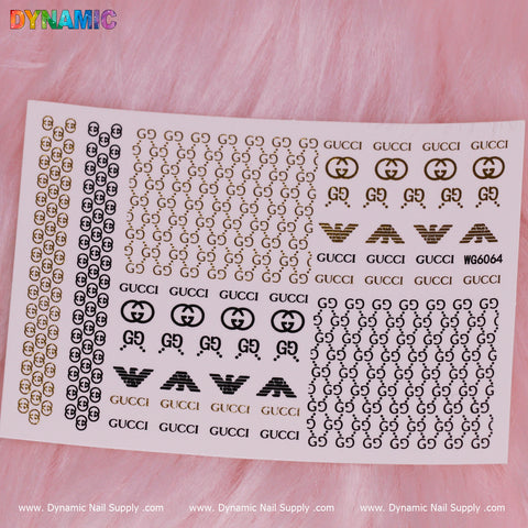 A sheet of luxury style nail stickers is set against a pink fur background, showcasing designs like small gold and black circles with GG logos, as well as the word GUCCI in gold and black text. In the top left corner, the brand Dynamic Nail Supply is displayed in colorful letters alongside model number WG6064.