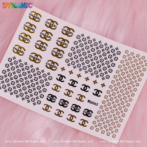 Experience the elegance of the Luxury Style Water Decal (WG6063) by Dynamic Nail Supply, embellished with gold and black designs such as interlocking CC logos and brand motifs. Set against a soft pink fur texture backdrop, this decal enhances your style with its refined geometric patterns.