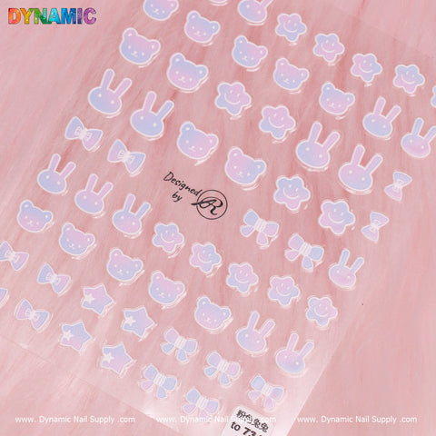 A pastel-colored sheet featuring the "Gradient Bear and Rabbit Sticker" from Dynamic Nail Supply is set against a pink background. It showcases charming designs including rabbit stickers, gradient bears, smiley faces, and stars in light blue and pink shades. The logo of Dynamic Nail Supply and the phrase "Designed by LQ" are prominently displayed at the top.