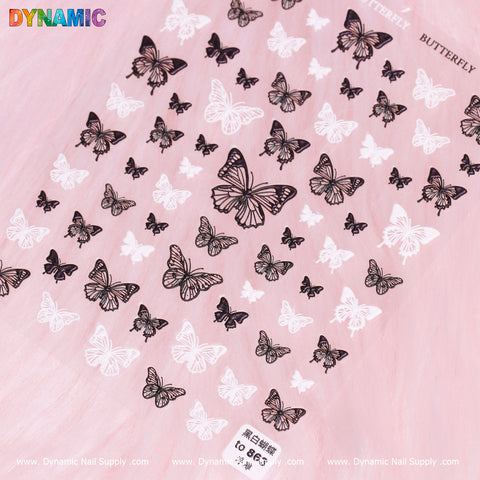 The Black and White Butterfly Sticker (863) from Dynamic Nail Supply displays multiple butterfly decals in various sizes against a soft pink background. "BUTTERFLY" is elegantly positioned on the top right, with "DYNAMIC" adding a splash of color to the top left. The bottom includes a website address for easy access to further explore design 863.