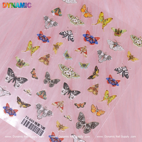 An Antique Butterfly Sticker sheet from Dynamic Nail Supply (TS-669) rests on a light pink surface. The stickers display a variety of butterfly and moth species adorned with colorful and intricate designs, featuring hues of blue, orange, yellow, and patterned black and white. A barcode along with the text "Dynamic Nail Supply TS-669" is visible at the bottom.
