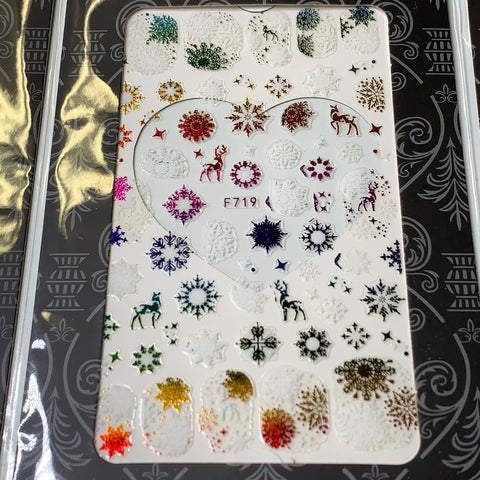 The Dynamic Nail Supply Bundle of 20pcs Christmas Nail Stickers, priced at $30, showcases a variety of festive designs including colorful snowflakes, reindeer, and trees encircling a central heart shape. Each sticker is intricately crafted with metallic gold, silver, red, green, and multicolored patterns for unique holiday nail art decoration.