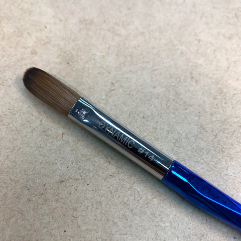 A close-up of a Crimped Dynamic Kolinsky Brush from Dynamic Nail Supply rests on a beige surface. This brush, perfect for acrylic nails application, features fine, soft bristles made from 100% pure Kolinsky hair. Its metal ferrule is engraved with DYNAMIC #14, while the glossy, faceted handle subtly reflects light.