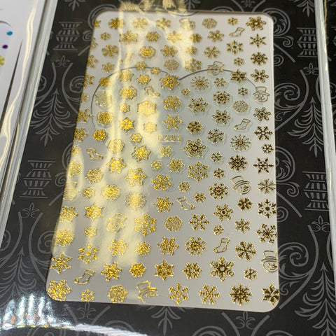 A close-up of the Bundle of 20pcs Christmas Nail Stickers by Dynamic Nail Supply, priced at $30, showcases intricate gold designs featuring snowflakes, stockings, and Santa Claus faces. The background is white adorned with an ornate black and silver border.