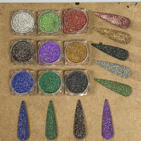 Nine small circular containers of Reflective Glitter, featuring the Super Sparkle Disco Glitter collection by Dynamic Nail Supply, come in various colors such as silver, green, red, black, purple, gold, and blue. They are arranged in four rows with teardrop-shaped samples to the right that highlight the super flash textures for each shimmering hue.