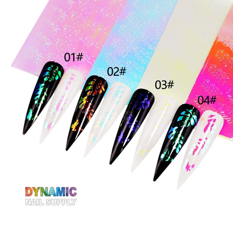 A set of four elongated, pointed nails adorned with holographic leaf stickers from the "Hot Design 16pcs/set" collection by Dynamic Nail Supply. Each nail displays a distinct color number: 01#, 02#, 03#, and 04#. The backdrop glistens with vibrant, iridescent sheets, while "Dynamic Nail Supply" is artistically presented at the bottom in a rainbow gradient.
