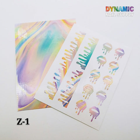 Displayed is the Hot Designs - Lips Sticker for Nails Art Decoration set, which showcases a rainbow effect with drip patterns and abstract swirls on a white background. These stickers, ideal for decorating nails, boast a glossy, iridescent finish. The top right corner features "Dynamic Nail Supply" in colorful letters, while the bottom left displays "Z-1.