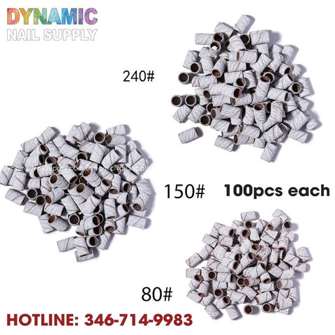 Zebra Sanding Bands from Dynamic Nail Supply, available in grits 240#, 150#, and 80#, are neatly arranged in piles of 100 pieces. The brand name "DYNAMIC NAIL SUPPLY" is prominently displayed alongside the contact number HOTLINE: 346-714-9983. These bands are perfect for enhancing your manicure tools collection as essential accessories for nail drill bits.