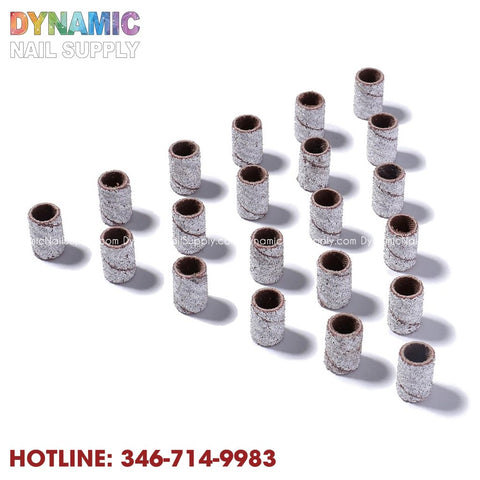 Image featuring 20 small, cylindrical sanding bands neatly arranged in rows on a white background. These greyish bands, ideal for use as Machine Nail Drill Bits Zebra Sanding Bands, offer a rough texture for efficient sanding during foot care or manicure processes. The Dynamic Nail Supply logo is displayed at the top left corner, with the contact number 346-714-9983 in red at the bottom left.