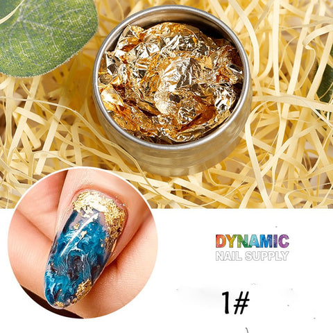 A small round container, filled with crumpled pieces of gold foil from the Big Size 14cm Nail Foil paper for Nail Art Design, rests on a bed of shredded straw. Below, a close-up reveals a thumbnail featuring blue marble and gold foil nail art, enhanced by products from Dynamic Nail Supply. The image includes the text "DYNAMIC NAIL SUPPLY" and "#1".