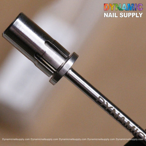 A close-up shot highlights the Easy-Off Sanding Band Mandrel by Dynamic Nail Supply, showcasing its high-quality metal cylindrical shape with grooves and ridges perfect for nail art. The vibrant logo of Dynamic Nail Supply complements the brand name, while the blurred background draws attention to the mandrel and its compatible sanding band.
