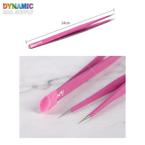 A close-up image showcases the Nails Art tweezer double-head by Dynamic Nail Supply, featuring sharp pointed tips and measuring 14 cm. The tweezers are displayed on a marble surface, with the brand name prominently visible on the side. The colorful background spells out "DYNAMIC NAIL SUPPLY," emphasizing the precise design ideal for manicure and nail art.