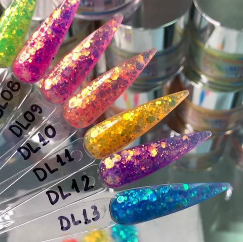 A close-up shot showcases six nail polish swatches from the Dynamic Nail Supply's "New Neon Glitter Acrylic Collection for the Summer 2021," labeled DL08 to DL13. Each swatch features long, pointed tips with a vibrant neon glitter acrylic finish. The collection offers a color palette ranging from pink and yellow to purple and blue, ideal for long-lasting wear. Blurred jars of nail products create the backdrop.