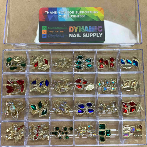 The clear plastic organizer box is filled with the 120-piece set of sparkling nail charms, featuring vibrant hues such as red, green, blue, and iridescent. Attached to the inside of the lid is a business card from Dynamic Nail Supply, providing contact information to easily access your favorite nail supply essentials.
